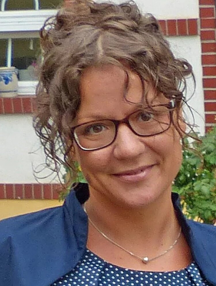 Portrait Jessica Stubenrauch - junge Frau mit Brille und lockigen Haaren